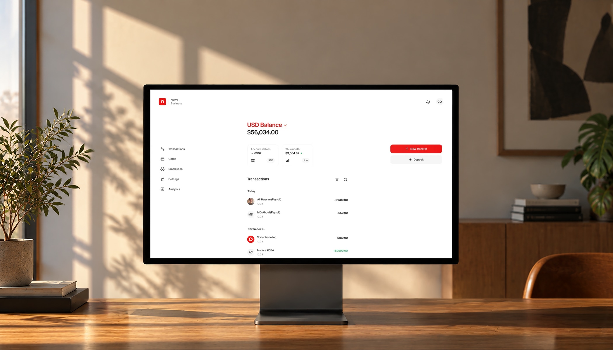 nsave business dashboard showing a USD balance and transactions on a desktop monitor in a warm office